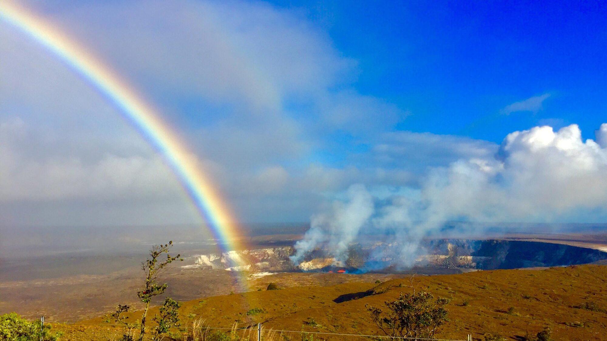 gorgeous shot of rainbow over a smoldering caldera