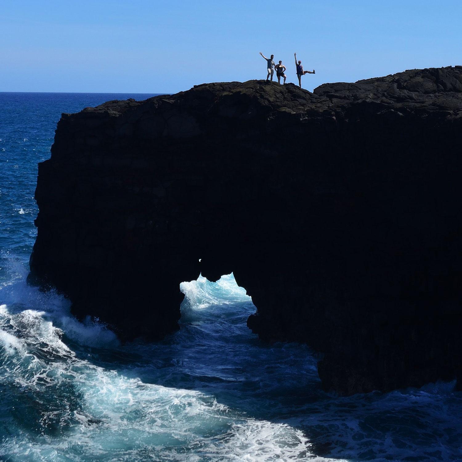 people standing on top of a large rock formation